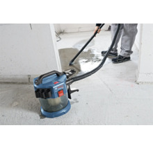 Aspirateur eau et poussière sans fil Bosch Professional aspirant de l eau sur un sol en béton.