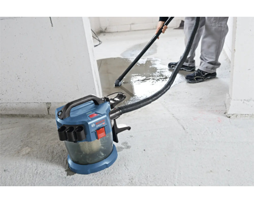 Aspirateur eau et poussière sans fil Bosch Professional aspirant de l eau sur un sol en béton.