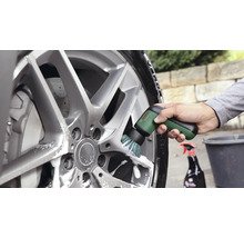 Utilisation de la brosse de nettoyage électrique Bosch UniversalBrush pour nettoyer une jante en aluminium avec de l'eau savonneuse.