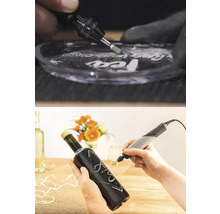 Dremel Multifunktionswerkzeug beim Gravieren von Glas und einer dunklen Glasflasche.