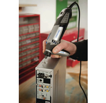 Person nutzt ein Dremel 4000 Multifunktionswerkzeug mit Präzisionshandgriff zum Gravieren eines Metallgehäuses in einer Werkstatt.