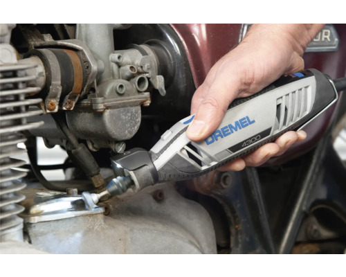 Outil multifonction Dremel 4300 avec éclairage LED intégré utilisé sur un moteur de moto.