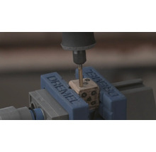 Dremel Rotationswerkzeug bohrt Löcher in einen Holzwürfel, der in einem Dremel Schraubstock eingespannt ist.
