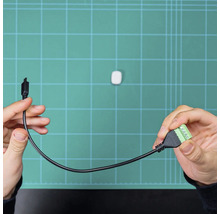 Câble adaptateur avec un connecteur noir et un bornier vert avec des bornes à vis.