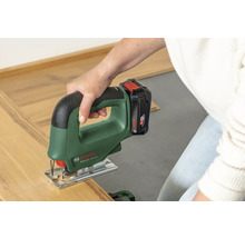 Eine Person schneidet mit einer Bosch Akku-Stichsäge EasySaw 18V-70 ein Stück Laminatboden.