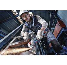 Handwerker in Schutzkleidung bearbeitet eine Stahlkonstruktion mit einem Akku-Winkelschleifer unter Funkenflug.