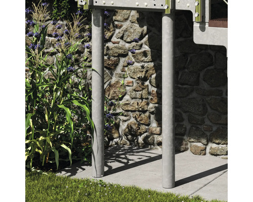 Deux poteaux de support métalliques verticaux pour un escalier extérieur ou une plateforme, placés devant un mur en pierre.