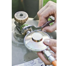 Utilisation d'une clé pour détendeur CFH pour serrer un régulateur de pression sur une bouteille de gaz, CFH Logo.