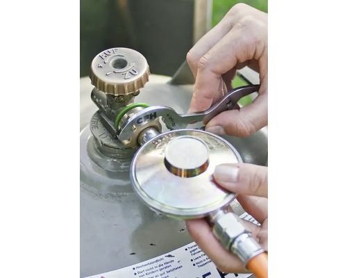 Utilisation d'une clé pour détendeur CFH pour serrer un régulateur de pression sur une bouteille de gaz, CFH Logo.
