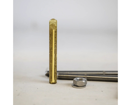 Ampoule de résine pour ancrage chimique avec tige filetée et écrou pour fixation de charges lourdes dans le béton.