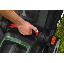 Main actionnant les leviers rouges d une tondeuse Bosch pour le réglage ou le pliage.