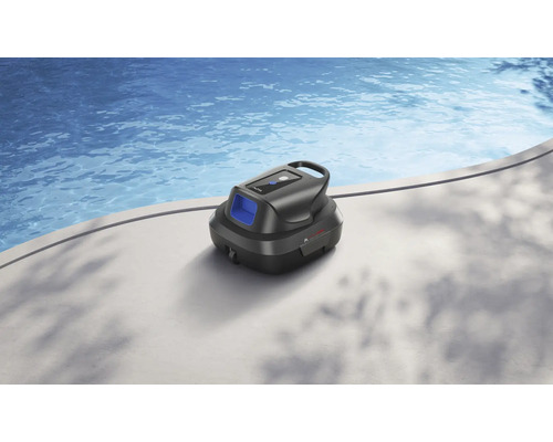 Ein schwarzer Poolroboter steht auf einem hellen Beckenrand neben einem Schwimmbecken mit blauem Wasser.