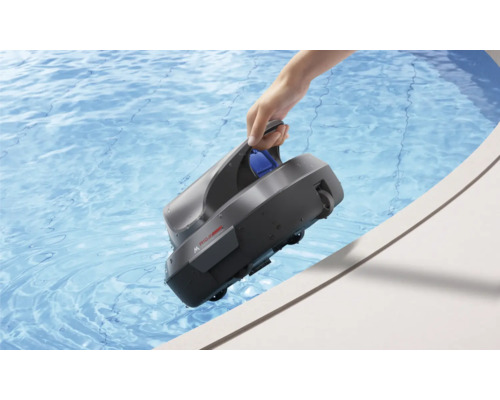 Eine Hand hält einen grauen Poolroboter am Griff über den Rand eines Schwimmbeckens mit klarem blauem Wasser.