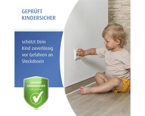 Jeune enfant assis sur le sol touchant une prise avec protection enfant. Sécurité enfant testée pour prises électriques.