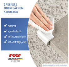 Hand reinigt einen weißen, bissfesten und speichelechten Eckenschutz an einer Tischkante. Leicht zu reinigen und schadstoffgeprüft. reer Logo.