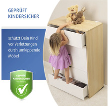 Ein kleines Kind klettert auf die Schubladen einer Kommode, um Spielzeug zu erreichen, symbolisiert Schutz vor umkippenden Möbeln, geprüft kindersicher.
