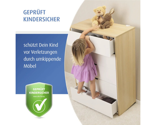 Ein kleines Kind klettert auf die Schubladen einer Kommode, um Spielzeug zu erreichen, symbolisiert Schutz vor umkippenden Möbeln, geprüft kindersicher.