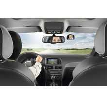 Heller Innenraum eines modernen Autos mit zusätzlichem Sicherheitsspiegel für Babys an der Windschutzscheibe, der ein Kind auf dem Rücksitz zeigt.