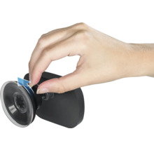 Eine Hand demonstriert das Lösen eines Saugnapfes an einer schwarzen Halterung durch Ziehen an einer Lasche.