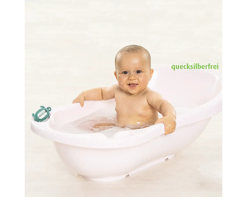 Baby an enger wäisser Babybidden mat engem Badethermometer, quecksilberfräi.