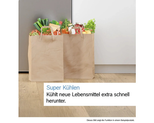 Zwei Papiertüten mit Lebensmitteln auf Holzboden vor einem Kühlschrank mit Text zu der Super Kühlen Funktion.