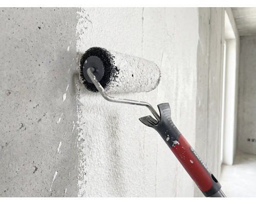 Rouleau à peinture Rautner appliquant de la peinture sur un mur en béton texturé.