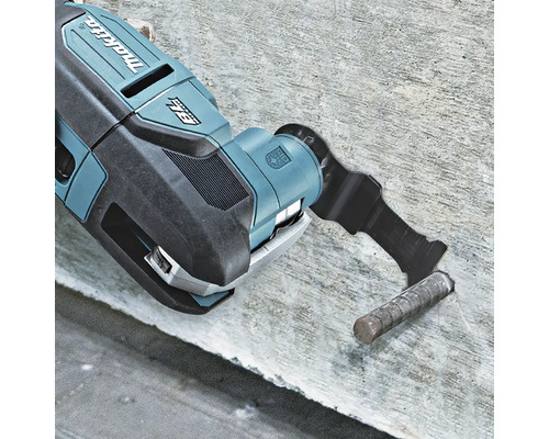 Makita Logo auf einem bürstenlosen Multifunktionswerkzeug, das einen Metallstab in einer Betonoberfläche bündig abschneidet.