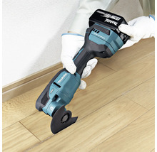 Makita Akku-Multifunktionswerkzeug mit 18 Volt Akku beim Schneiden von Holzboden.