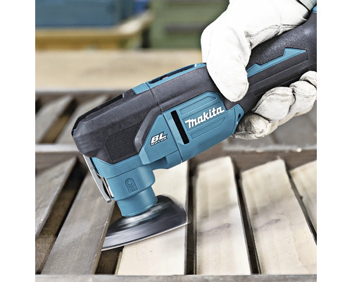 Makita Multifunktionswerkzeug mit Schleifplatte beim Schleifen von Holzlatten durch eine Person mit Arbeitshandschuh.
