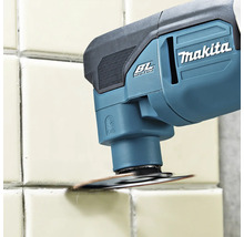 Makita Akku-Multitool mit bürstenlosem Motor beim Entfernen von Fugenmaterial zwischen Wandfliesen mit einem runden Werkzeugaufsatz.