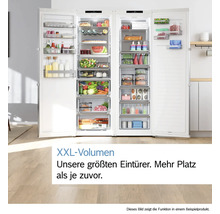 Vue claire et organisée d'un combiné réfrigérateur-congélateur ouvert avec volume XXL et de nombreux aliments sur des clayettes en verre.