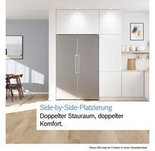 Réfrigérateur Side-by-Side en acier inoxydable dans une cuisine moderne et lumineuse avec des armoires blanches et parquet clair.