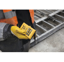 Télécommande Stabila pour laser de chantier, tenue par une personne en tenue de protection sur un chantier.