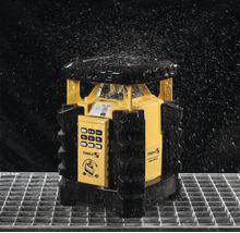 Laser rotatif Stabila LAR 350 protégé contre les projections d eau sur une grille métallique sous des gouttes d eau.
