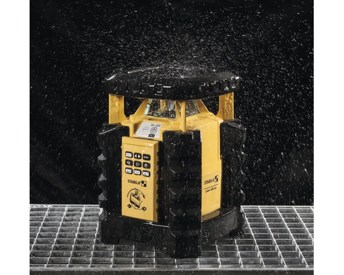 Laser rotatif Stabila LAR 350 protégé contre les projections d eau sur une grille métallique sous des gouttes d eau.