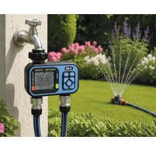 Programmateur d'arrosage avec for_q Logo monté sur robinet, deux tuyaux raccordés, arroseur de pelouse arrosant un jardin lumineux.