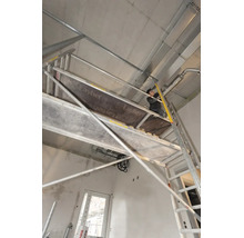 Handwerker op engem Layher Fahrgerüst bei der Installatioun un enger Betongsdecke am Rohbau.
