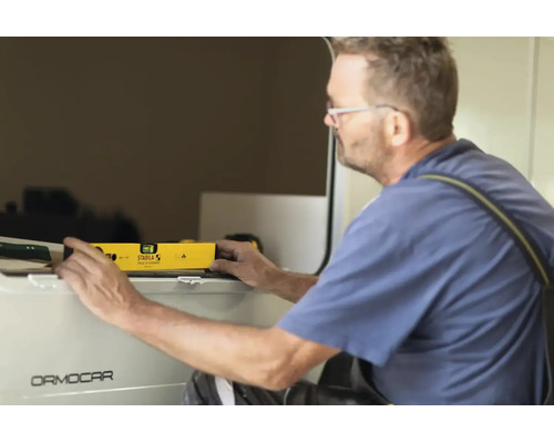 Handwerker mit Brille richtet ein Bauteil mit einer Stabila Wasserwaage aus.