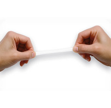 Zwei Hände dehnen einen elastischen Klebestreifen zur Demonstration der Flexibilität.