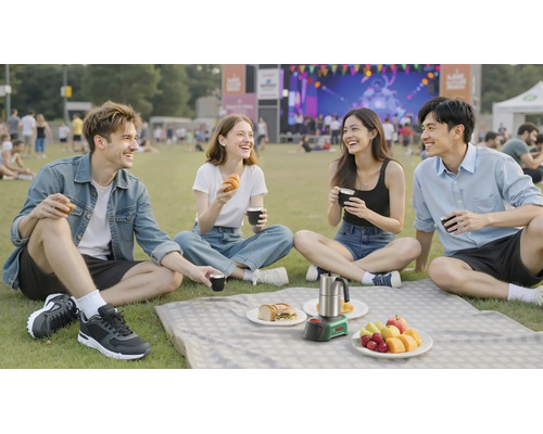 Vier Personen beim Picknick auf einer Wiese mit einer mobilen Bosch Kaffeemaschine und Snacks bei einer Außenveranstaltung.