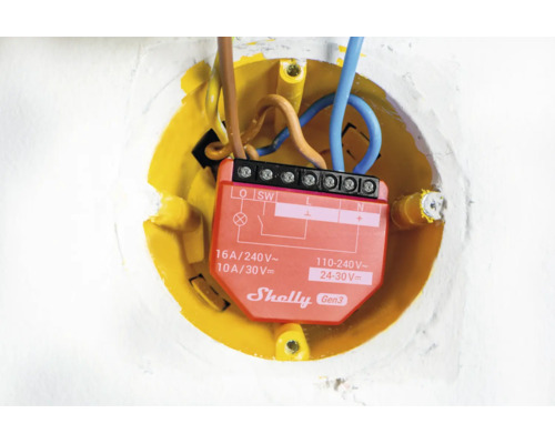 Commutateur relais intelligent Shelly Gen3 installé dans un boîtier d encastrement avec câbles connectés.