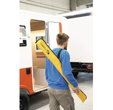 Homme avec un sac de transport Stabila pour niveaux à bulle sur l'épaule à côté d'un véhicule.