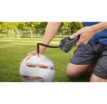 Pompe à air sans fil Bosch gonflant un ballon de football sur un terrain en herbe.