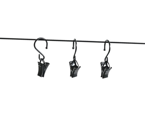 Trois pinces à rideaux noires avec crochets en métal, suspendues à une fine barre.