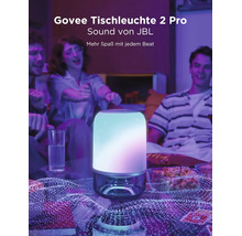 Lampe de table Govee 2 Pro avec son JBL dans un salon avec des personnes, un éclairage coloré et des collations.