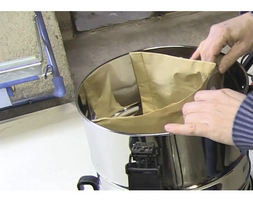 Insertion d'un sac filtrant en papier dans le réservoir en acier inoxydable d'un aspirateur eau et poussière.