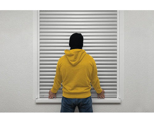 Protection contre les cambriolages à la fenêtre grâce à un volet roulant fermé avec une personne devant.