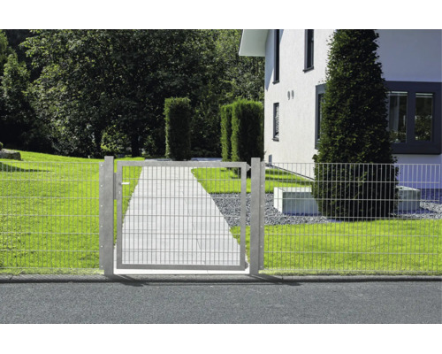 Portail de jardin à double fil dans une clôture devant une maison avec un chemin pavé et une pelouse.