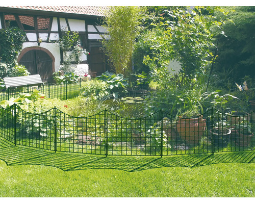 Clôture de jardin métallique verte installée autour d'un bassin avec des plantes, des pots en terre cuite et une maison.