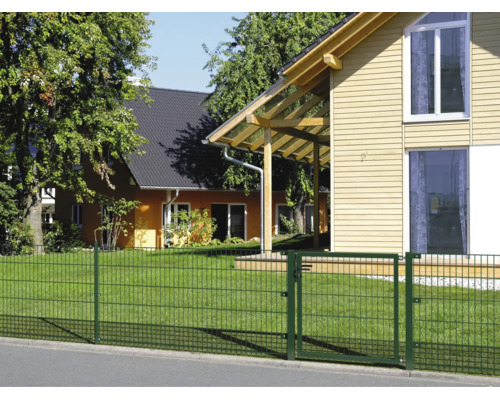Clôture à double fil avec portillon de jardin devant une maison et une pelouse.